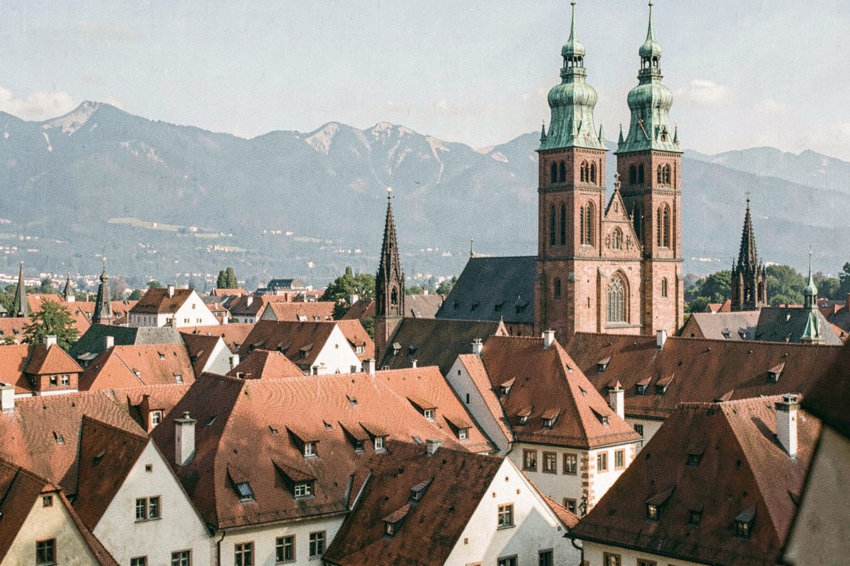 Old-town roofs and twin brick church towers with green domes in Munich (illustrative image)